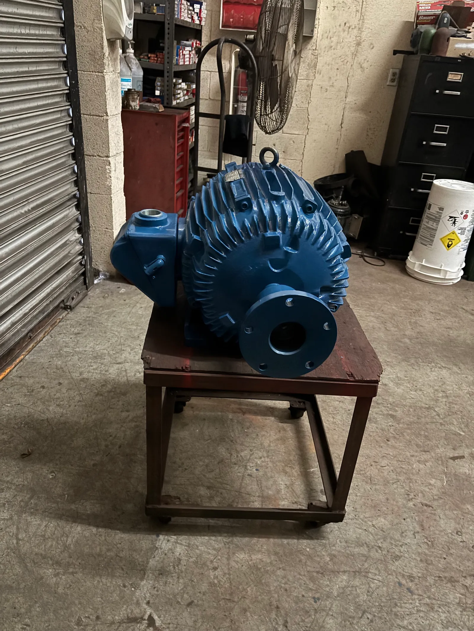 Overhauled elevator motor, freshly painted blue, on the shop cart
